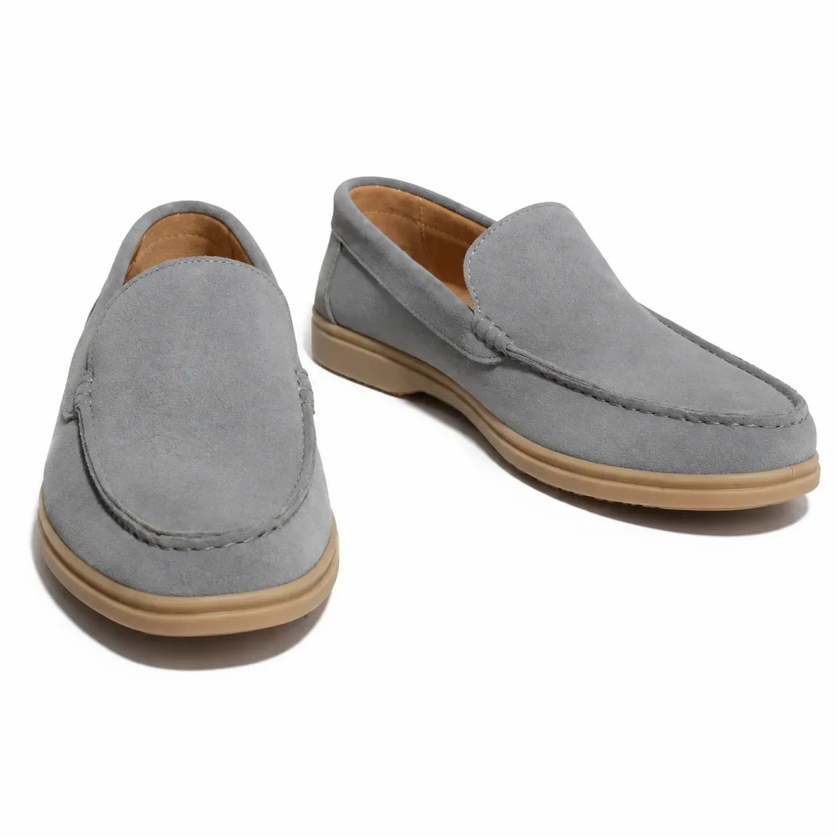 A pair of light gray suede slip-on loafers with tan soles,