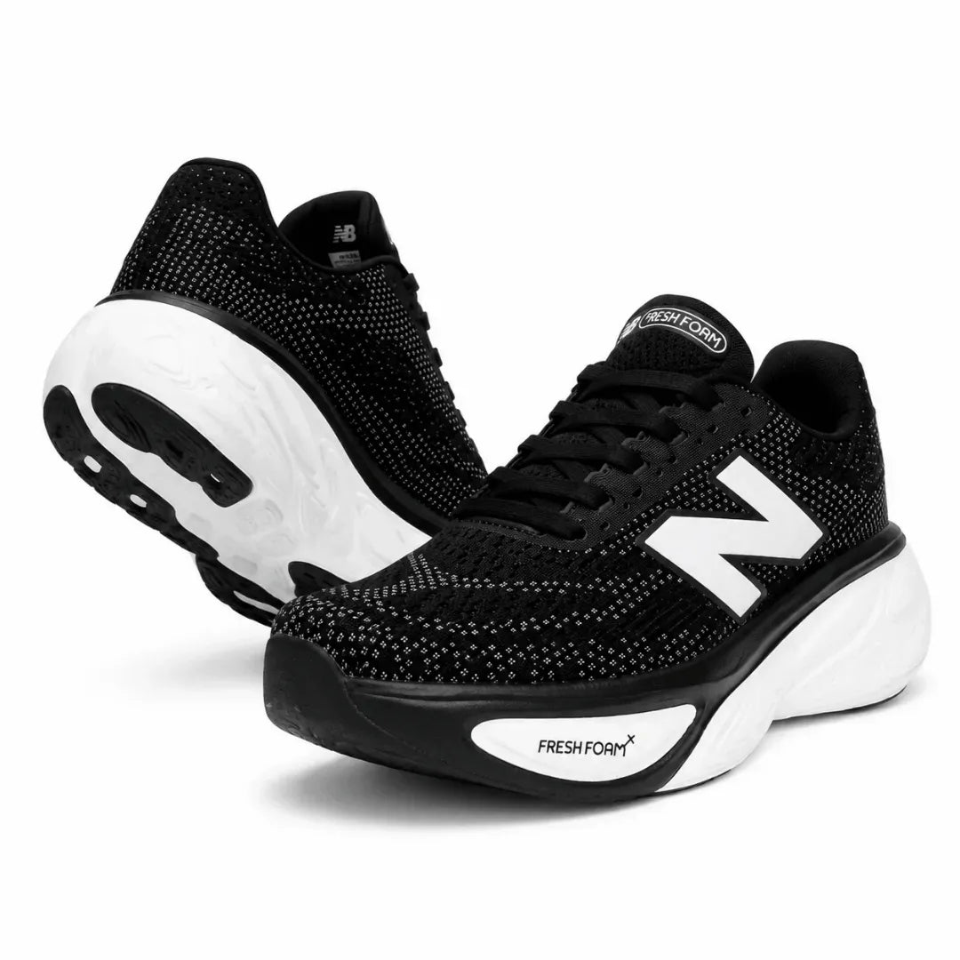 A pair of New Balance running shoes in black and white, featuring a breathable black mesh upper, a prominent white 'N' logo, and a thick white and black Fresh Foam midsole, set against a plain white background.