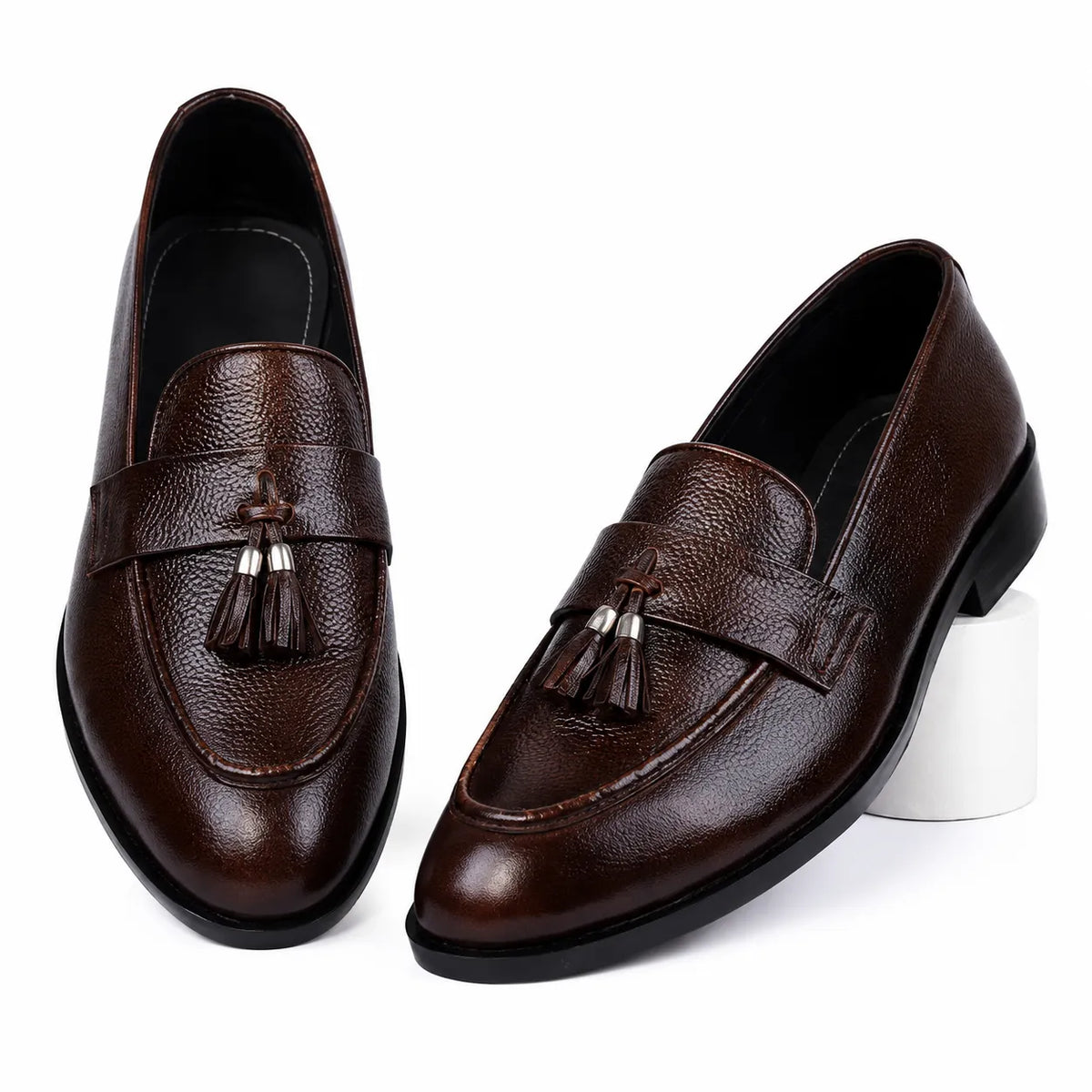 Dark brown leather tassel loafers for men on a white background