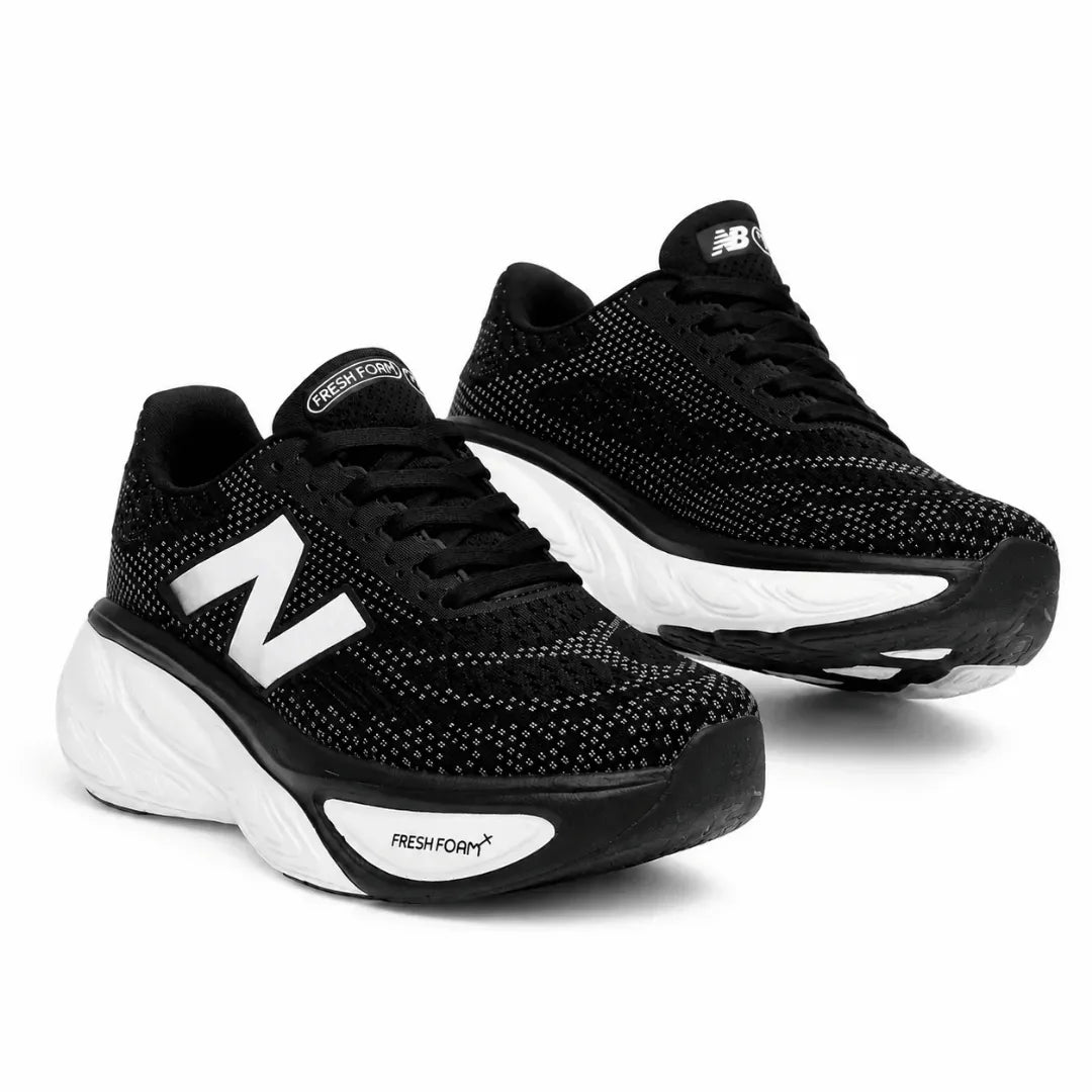 A pair of New Balance running shoes in black and white, featuring a breathable mesh upper, black laces, a thick white cushioned midsole, and a black outsole with white branding.
