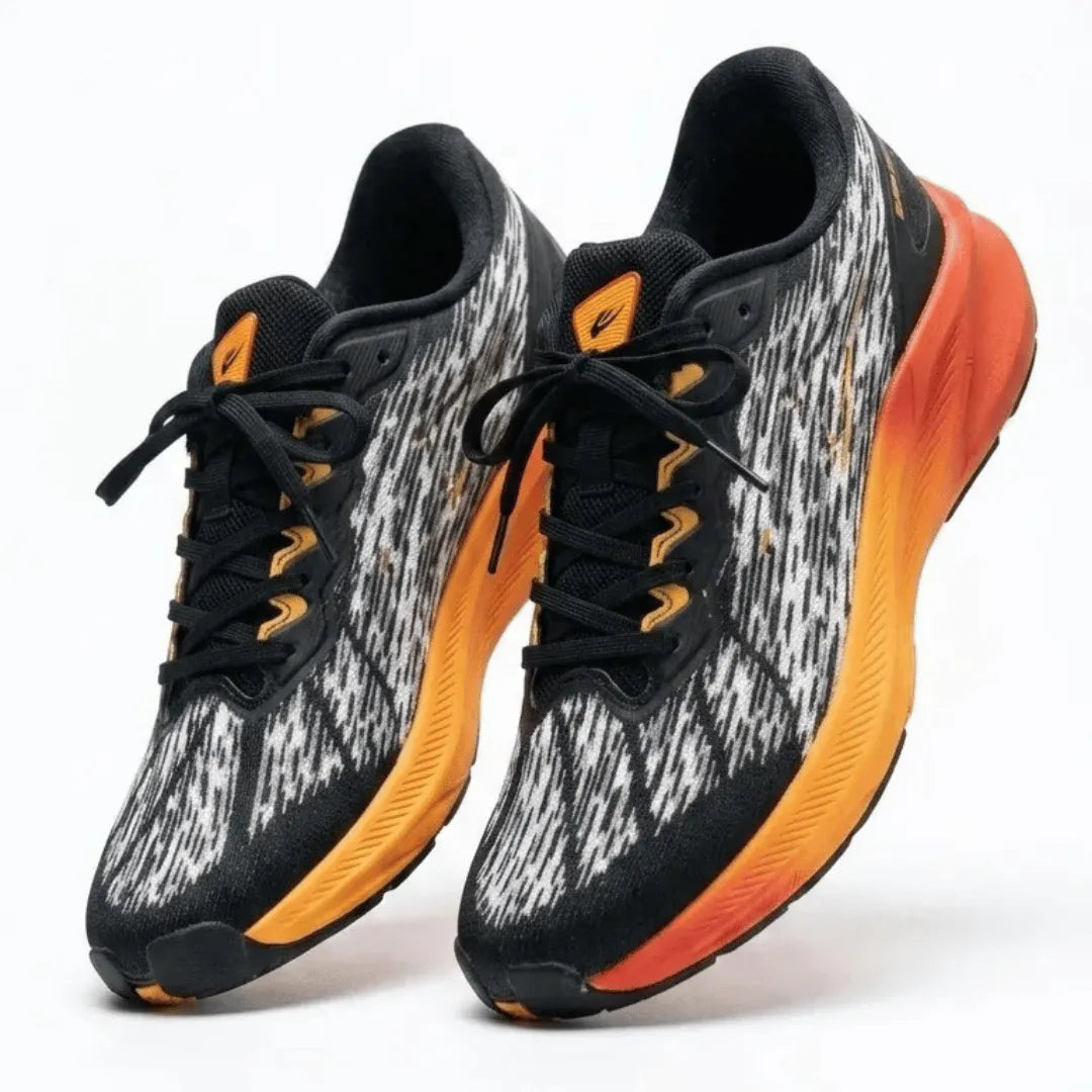 A pair of athletic sneakers with a black and white textured knit upper, black laces, and a vibrant orange-to-red gradient midsole, shown against a plain white background.