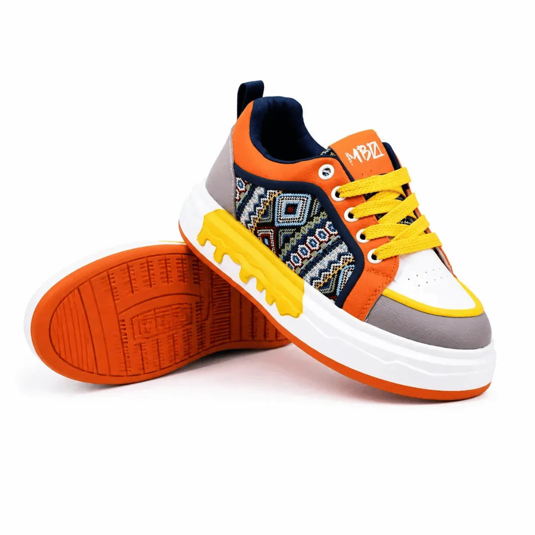 A low-top sneaker shown from the side and bottom, featuring a white, gray, orange, and yellow color scheme with a geometric pattern on the side panel and a white sole.