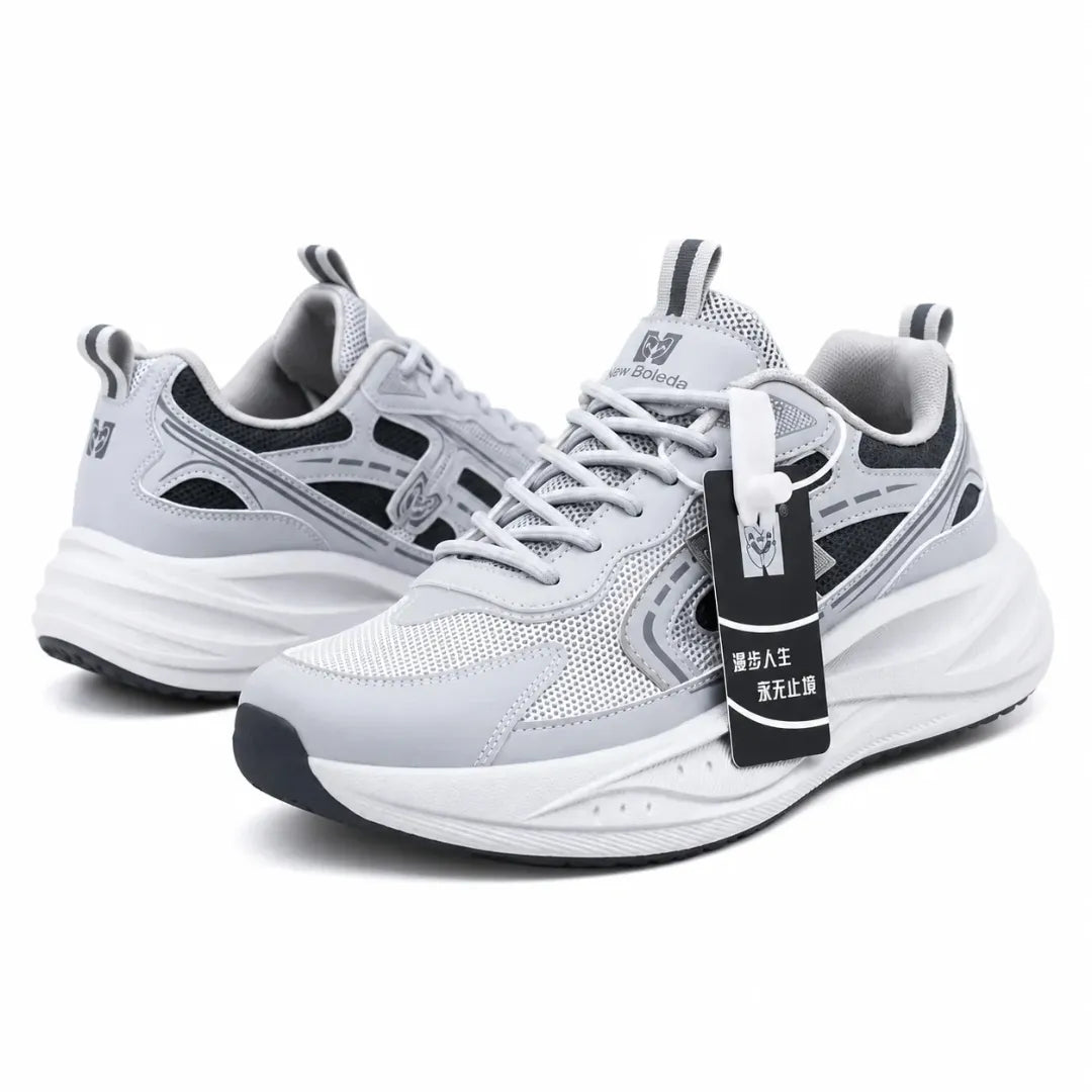A pair of light gray and white athletic sneakers with black accents, shown on a clean white background. One shoe is positioned behind the other, and a black hangtag with Chinese text is attached to the front shoe.