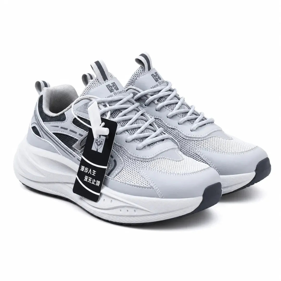 A pair of light gray and white athletic sneakers with black accents, featuring a chunky sole and a black hangtag with Chinese text, set against a plain white background.