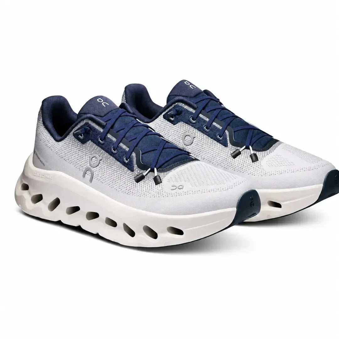A pair of On Cloudrunner running shoes in white and navy blue, shown from a three-quarters angle on a clean white background.