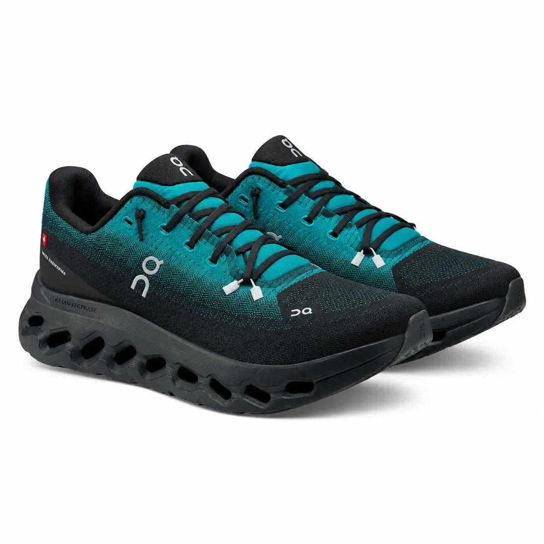 A pair of On Cloudrunning shoes in black and teal, featuring a breathable knit upper, black laces, and a distinctive black CloudTec sole, shown on a white background.