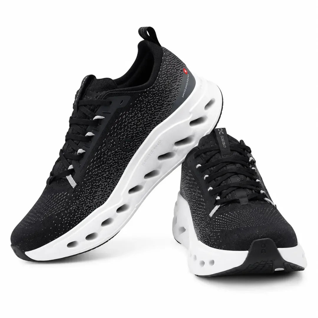 A pair of black knit athletic sneakers with thick white sculpted soles and black laces, shown on a clean white background.