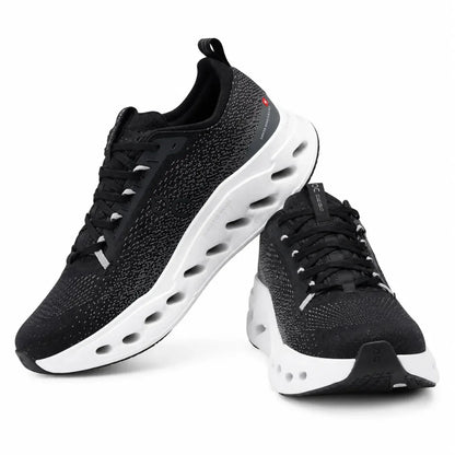 A pair of black knit athletic sneakers with thick white sculpted soles and black laces, shown on a clean white background.