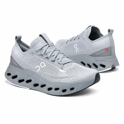 A pair of light gray On running shoes with a breathable mesh upper, thick cushioned sole, and visible On logo on the side, photographed on a clean white background.