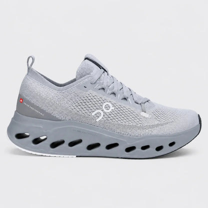 A light gray On running shoe with a distinctive sculpted sole featuring circular cutouts, shown in a side profile against a light gray background.