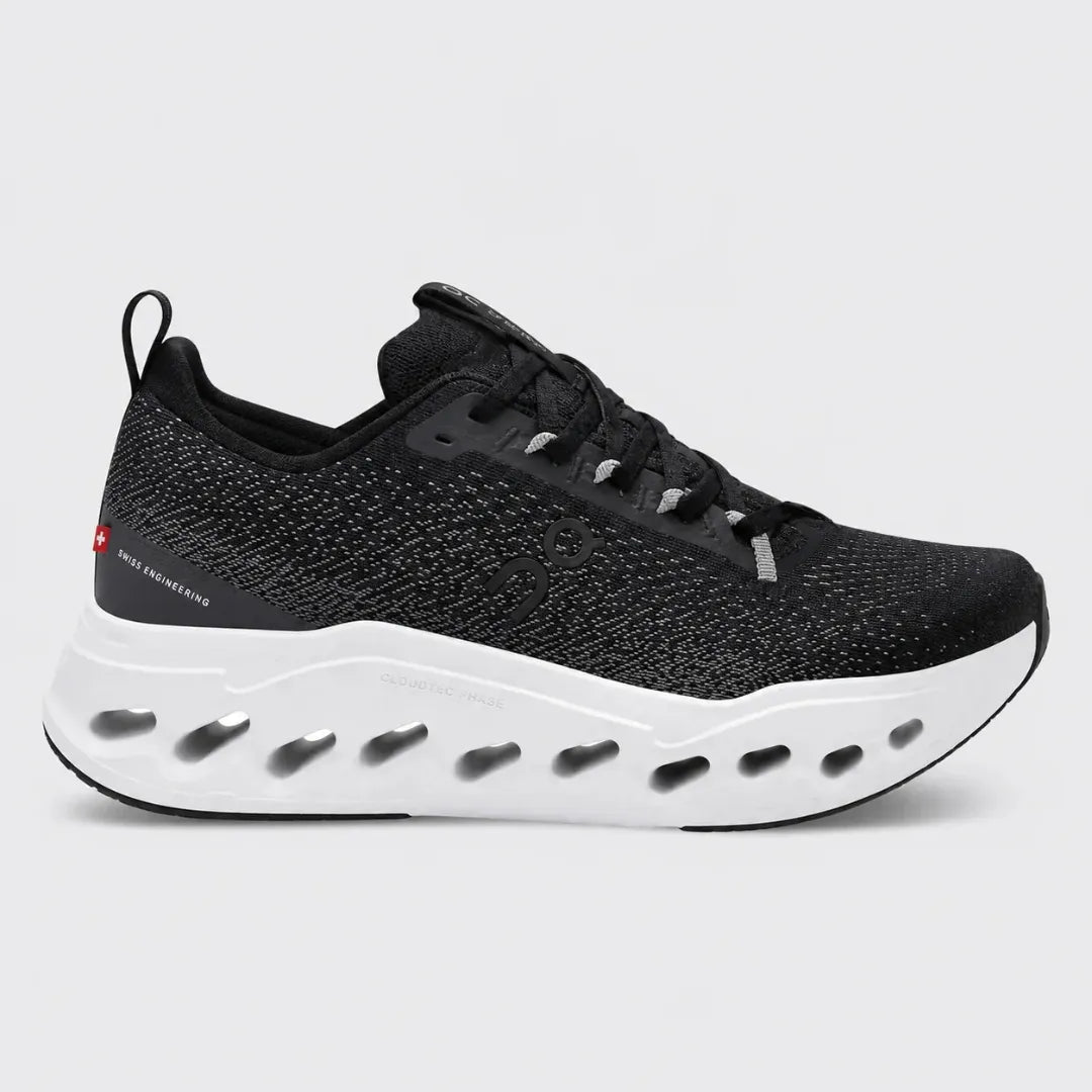 Black and green running shoe with white sole on a white background