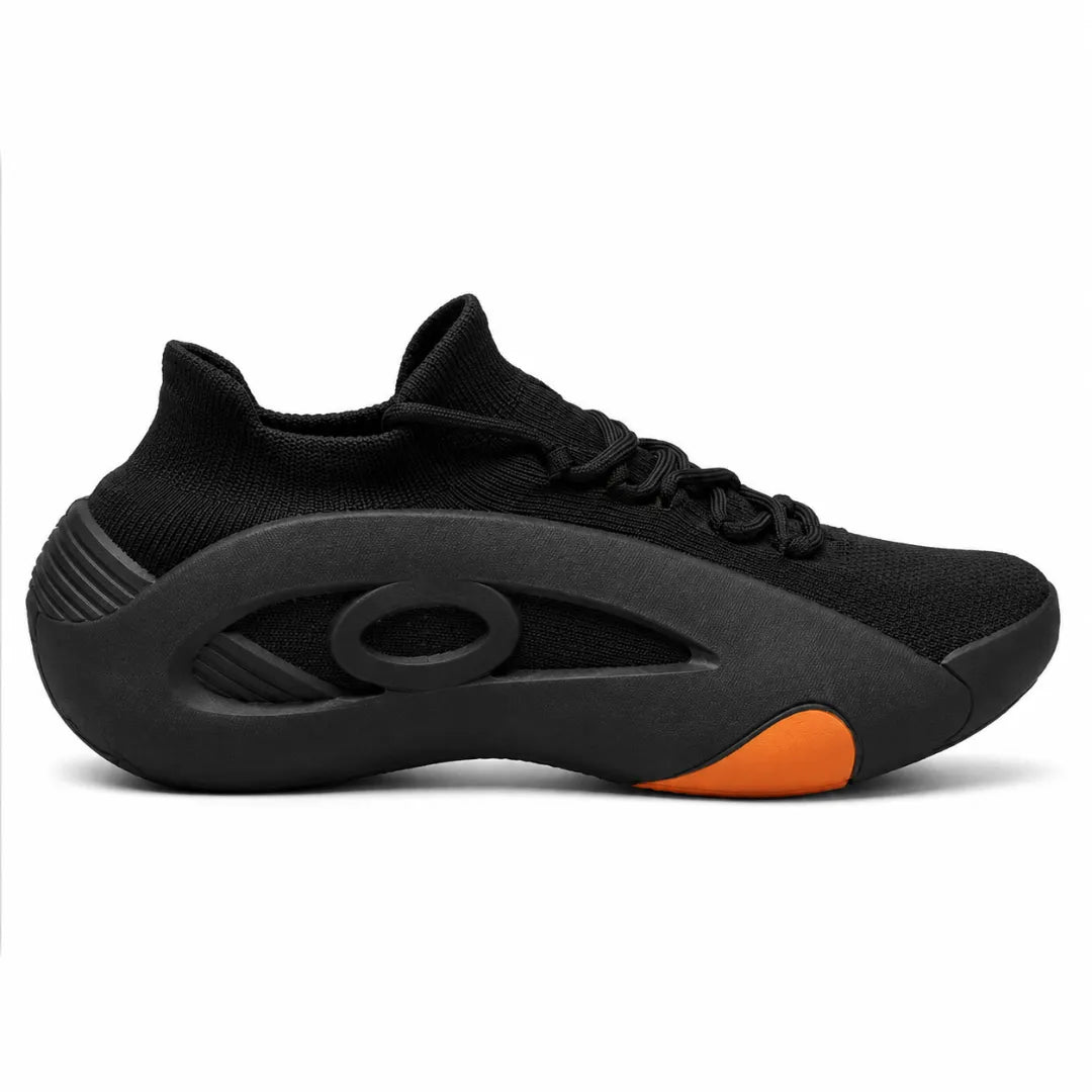 A black knit athletic sneaker with a thick sculpted black sole and a bright orange accent on the toe bumper, shown from a side profile on a white background.