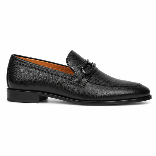 A single black leather penny loafer with a textured grain finish, low stacked heel, and a decorative strap detail on the vamp,