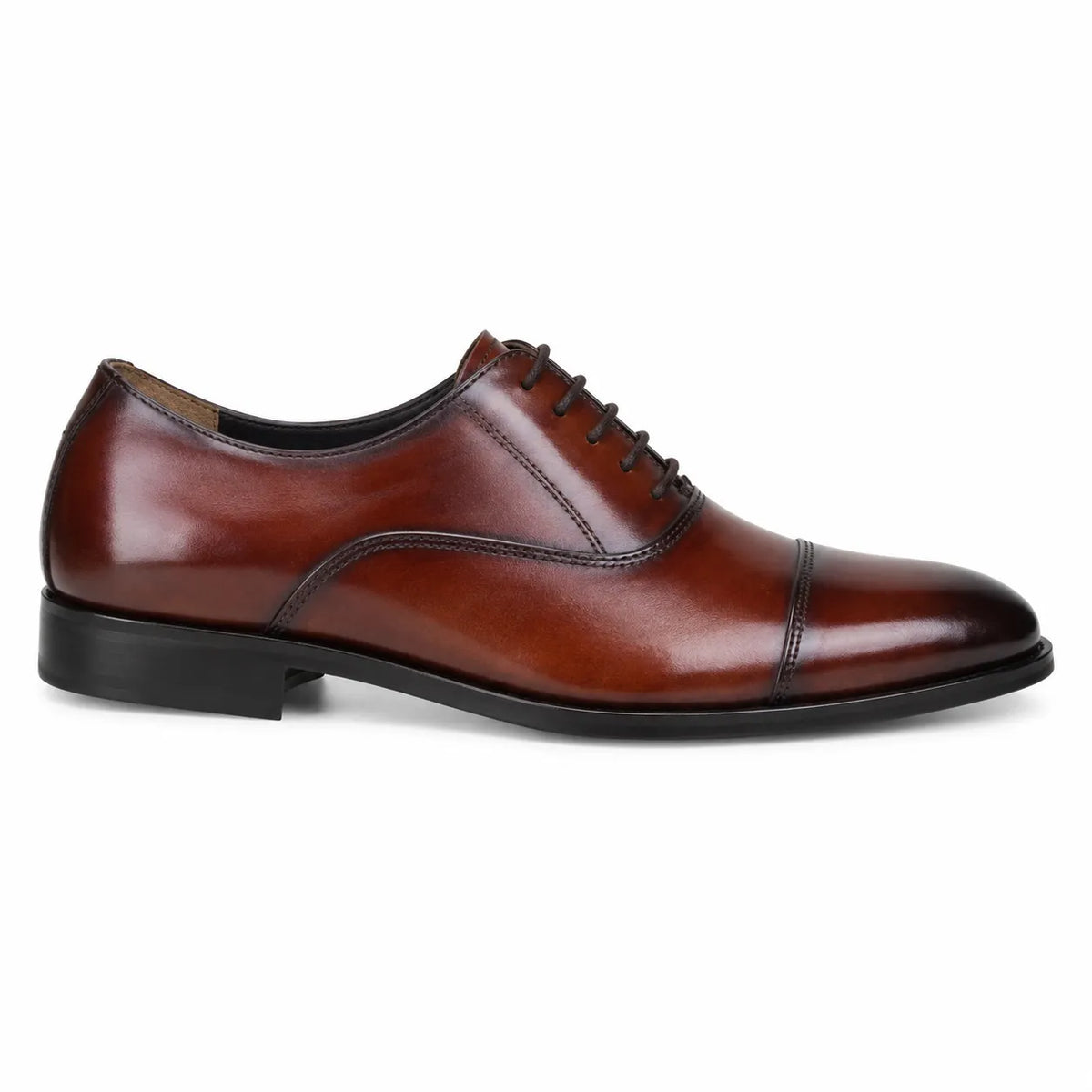 A classic men's oxford dress shoe in polished cognac brown leather with a black cap toe and black lace