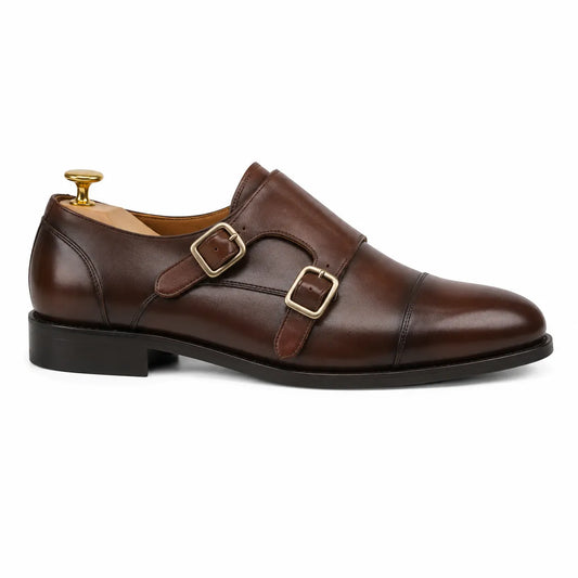 A dark brown leather double monk strap shoe with gold-tone buckle hardware
