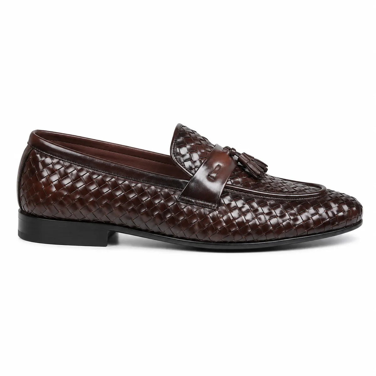 A dark brown woven leather loafer with a tassel detail on the strap