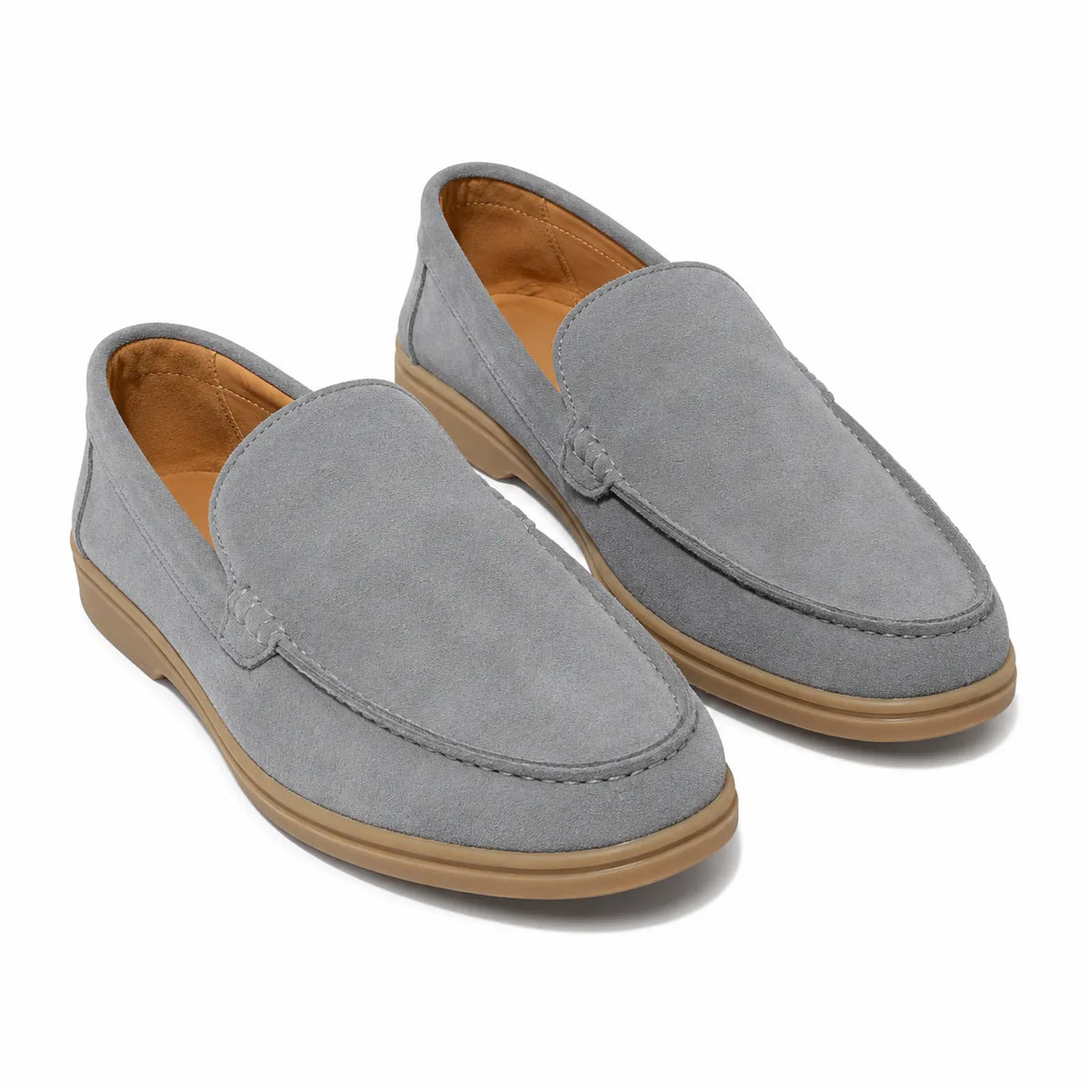 A pair of light gray suede slip-on loafers with tan soles for men