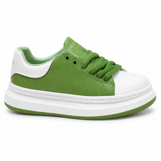 A low-top platform sneaker in green and white, featuring a thick white platform sole with a green edge, a white toe cap, and green laces, shown against a plain white background.