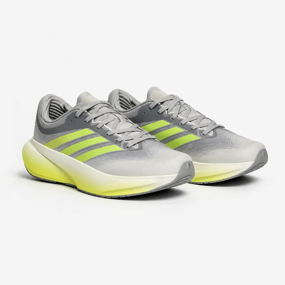 A pair of Adidas running shoes in gray and neon yellow-green, shown from a three-quarters angle on a light gray background.