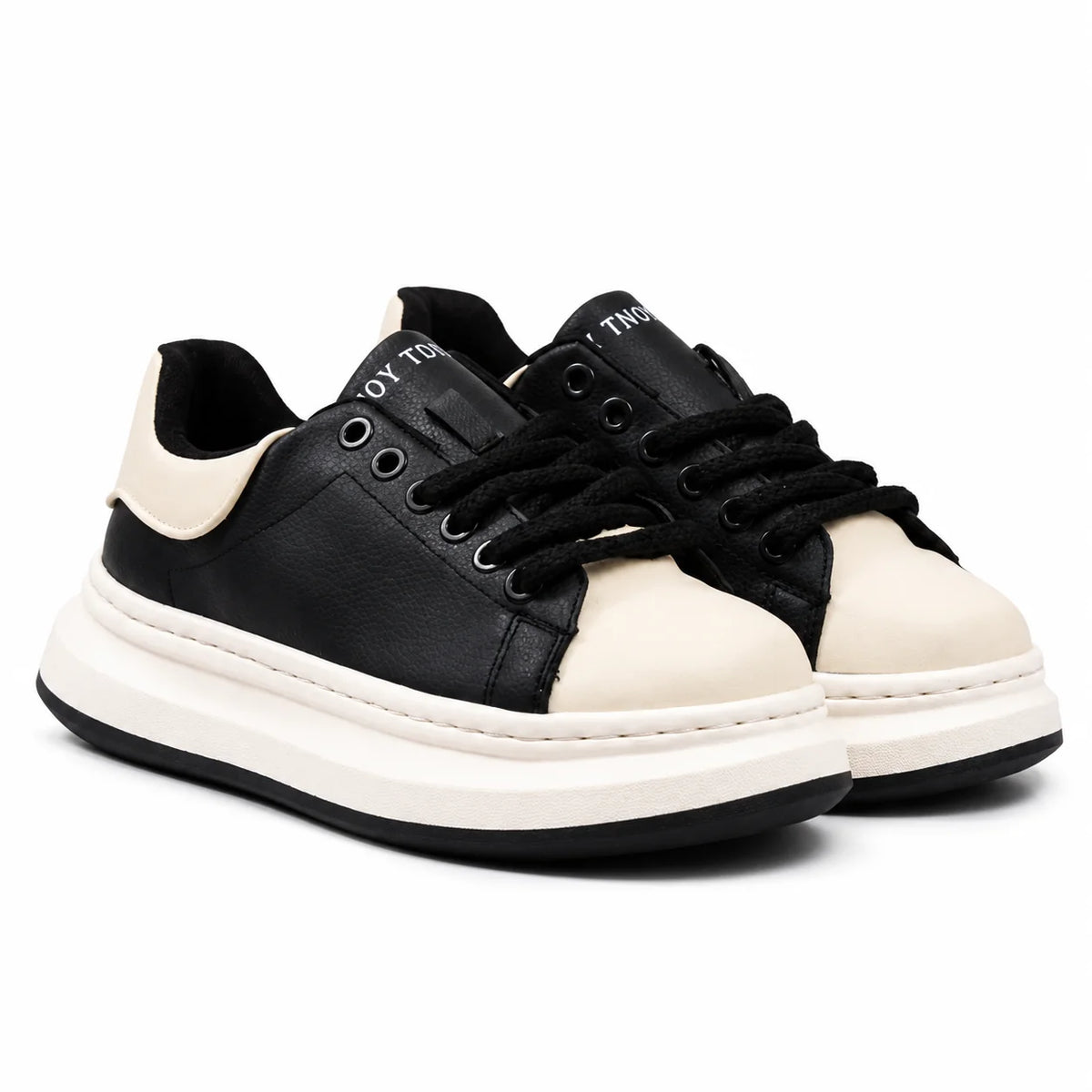 A pair of low-top platform sneakers in black and off-white. The shoes feature a thick white platform sole, black leather uppers, off-white leather toe caps and heel counters, black laces, and white text on the tongue reading 'THO.