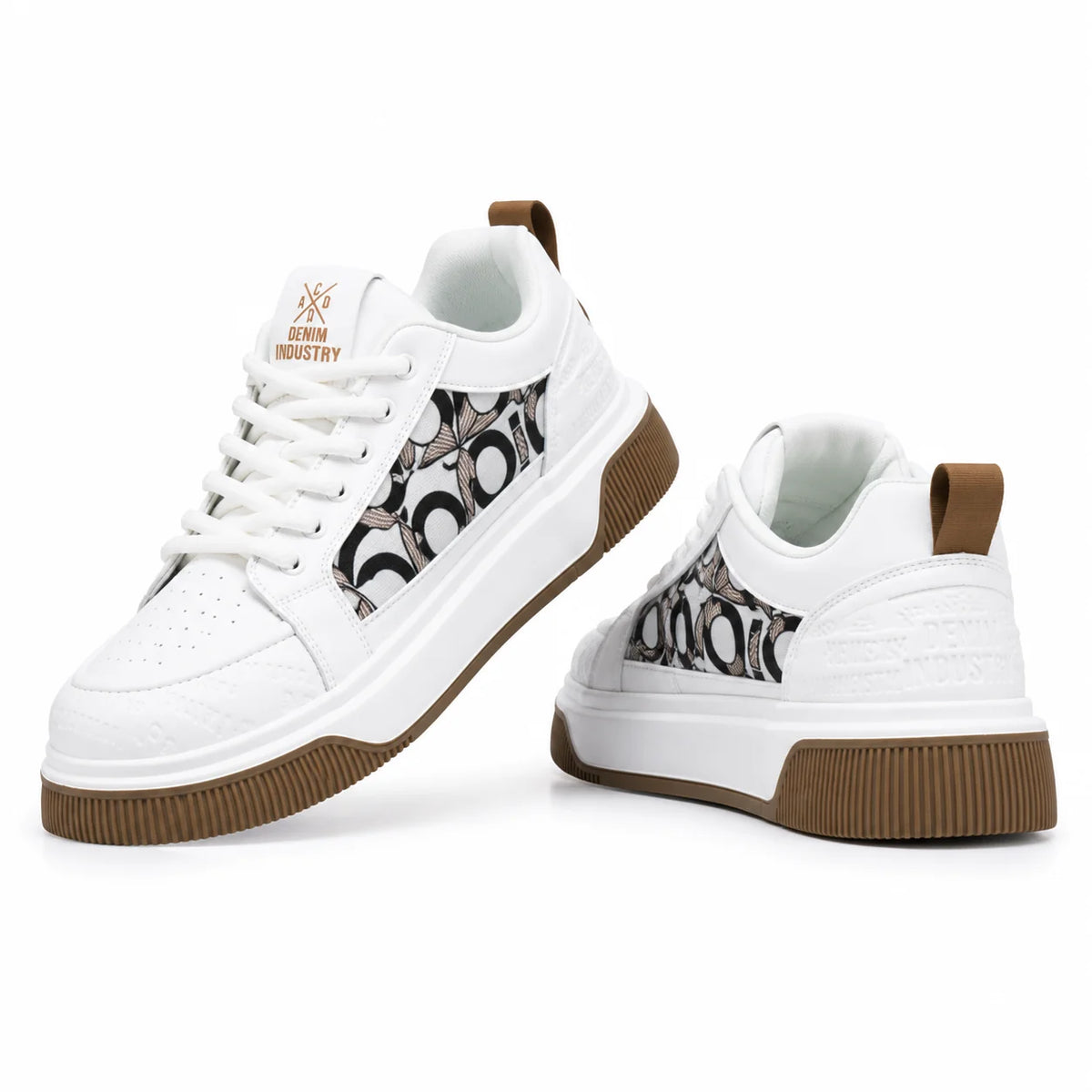 A pair of white low-top sneakers with brown rubber soles and a black-and-white patterned side panel, shown on a clean white background. One shoe is angled to show the side profile and the other shows the front three-quarter view.